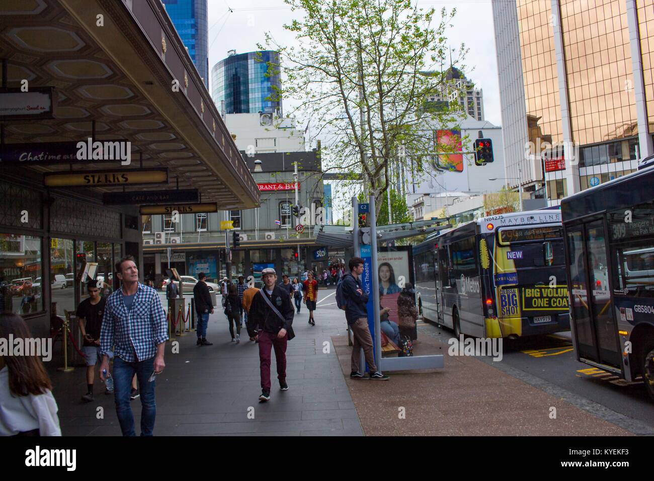 Les gens et les autobus de transport en commun sont visibles à l'extérieur des magasins de détail sur Queen Street, une rue commerçante populaire à Auckland, Nouvelle-Zélande, le 10 octobre 2017. () Banque D'Images