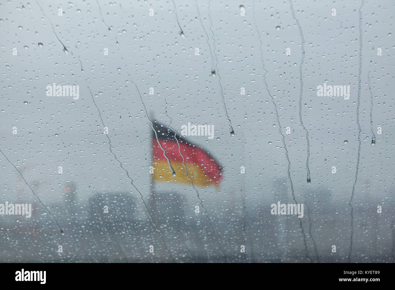 Drapeau national allemand représenté par le biais de gouttes de pluie sur la vitre de l'intérieur de la coupole du Reichstag à Berlin, Allemagne. Banque D'Images