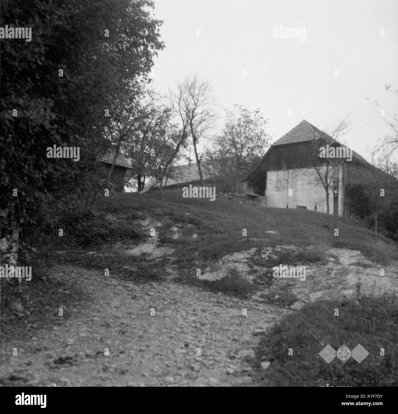 La photographie montre une croix traditionnelle de village à Železniki, Slovénie, prise en octobre 1965. L'image capture le patrimoine culturel de la région, reflétant les pratiques religieuses locales et les traditions communautaires. Banque D'Images