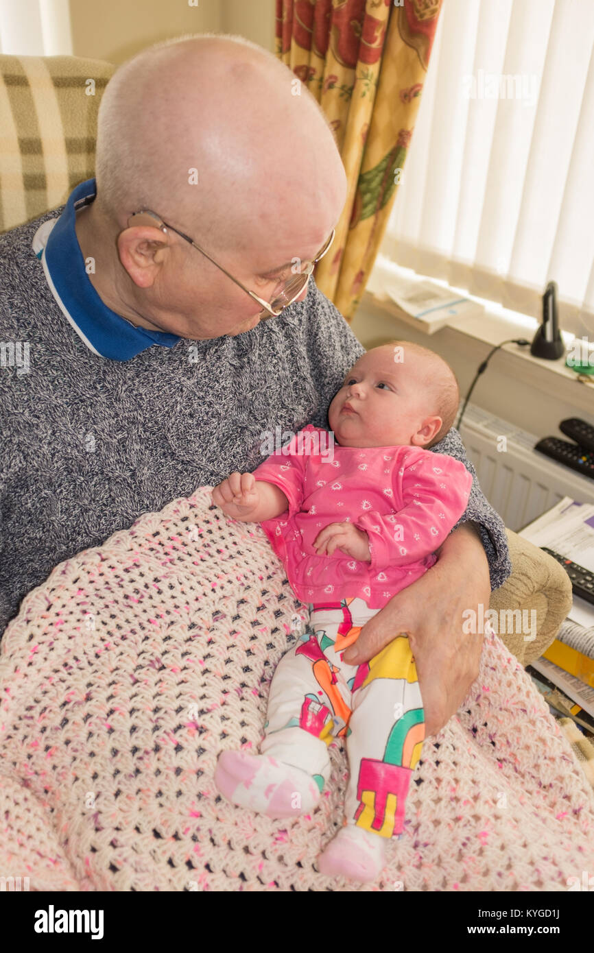 Naissance d'un bébé assis sur les genoux de son grand-père, à vers lui Banque D'Images