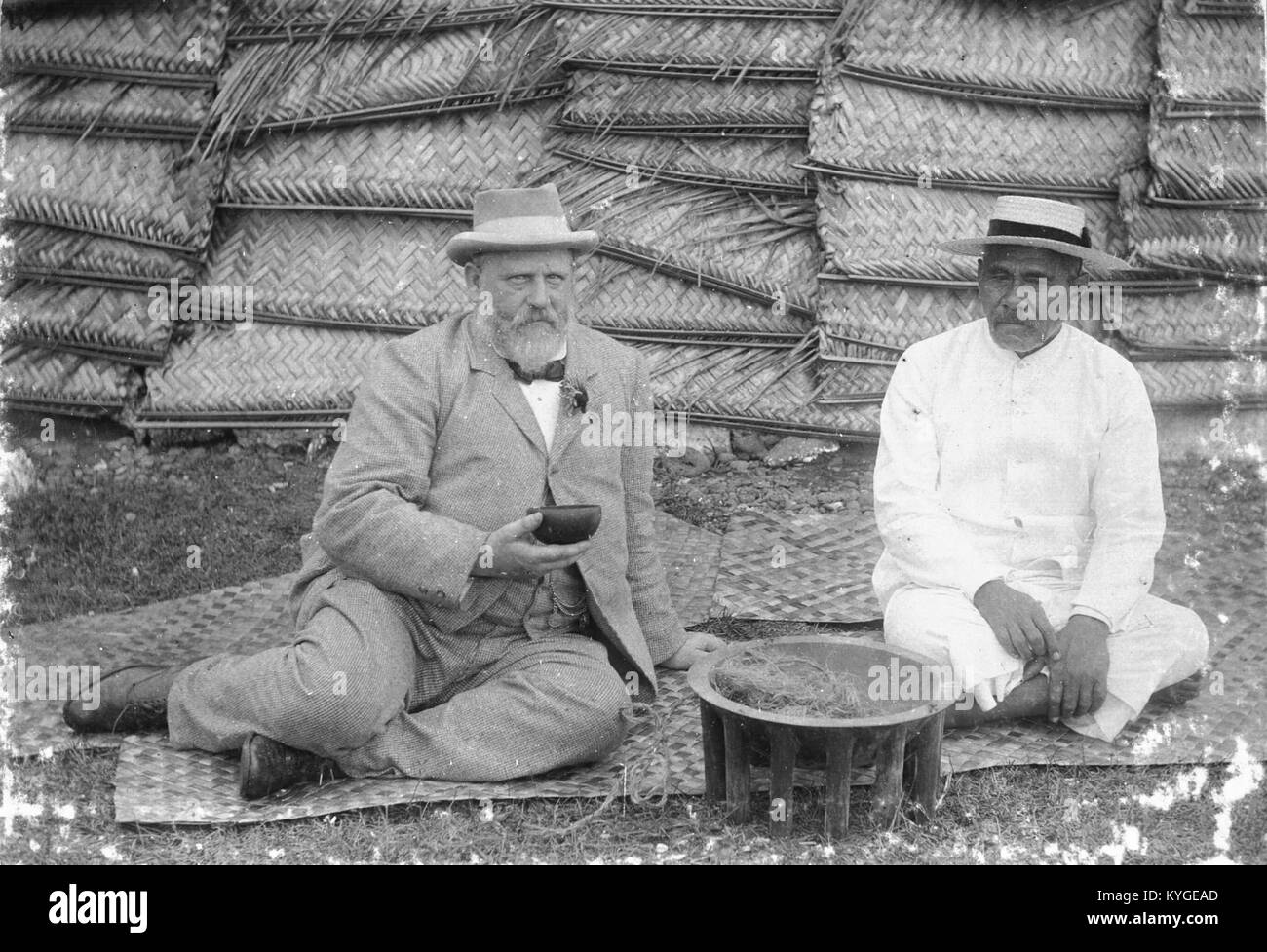 Photographie de 1897 représentant Richard John Seddon, premier ministre de Nouvelle-Zélande, et le roi Malietoa Laupepa des Samoa, assis sur une natte avec un bol de kava. Seddon tient une tasse de noix de coco. Capturé lors de la visite de Seddon aux Samoa. Banque D'Images