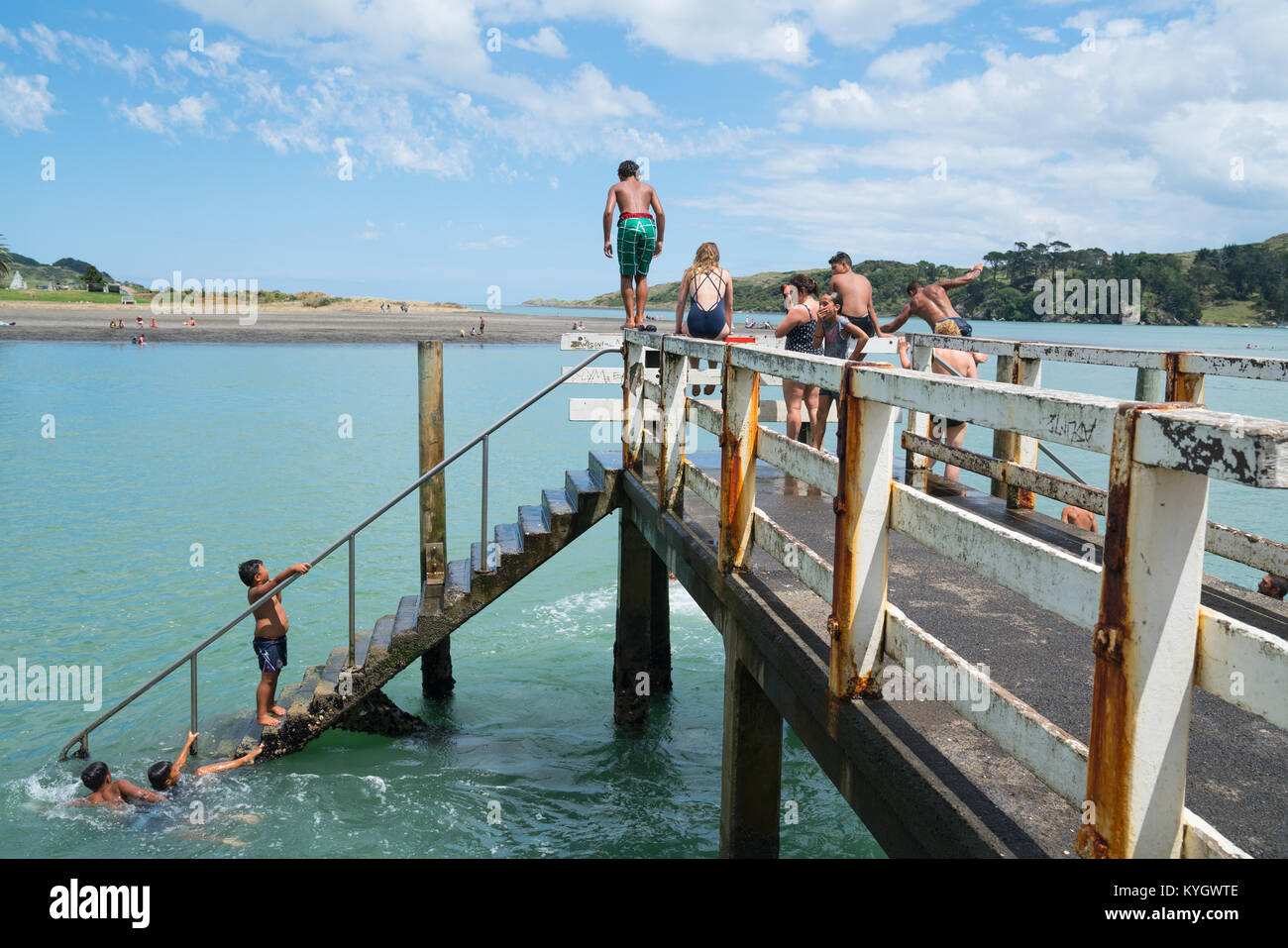 La NOUVELLE ZELANDE RAGLAN - janvier 14, 2018 ; Summer in Raglan principalement les garçons maoris locaux sauter du petit quai en petite ville de Nouvelle-zélande sur Nord Est Banque D'Images