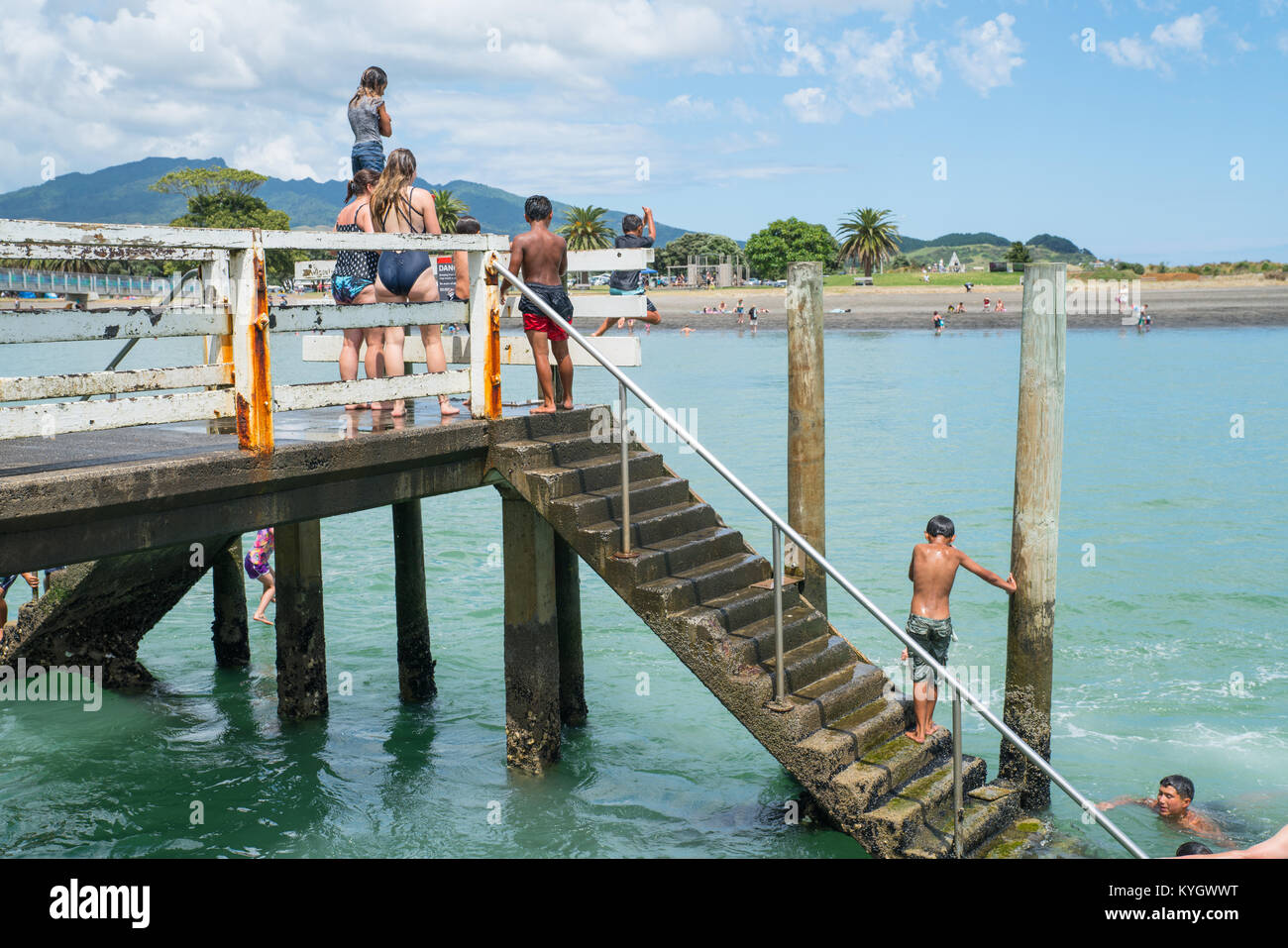 La NOUVELLE ZELANDE RAGLAN - janvier 14, 2018 ; Summer in Raglan principalement les garçons maoris locaux sauter du petit quai en petite ville de Nouvelle-zélande sur Nord Est Banque D'Images