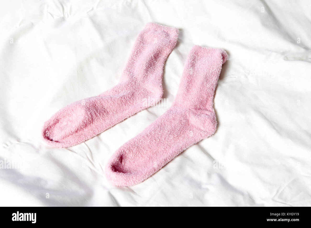 Chaussettes rose sur la couverture blanche Banque D'Images