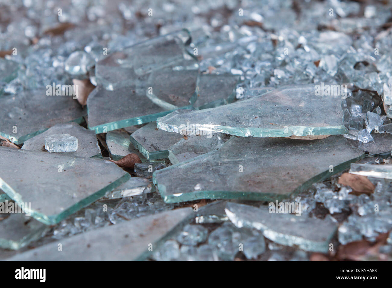 Des morceaux de verre brisé se situent sur la masse au bâtiment qui s'est retiré des affaires Banque D'Images