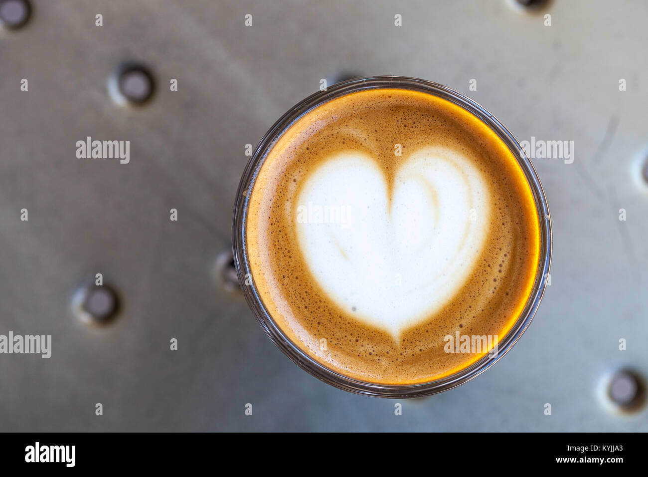 Vue de dessus du café cortado dans un verre avec de la mousse en forme de coeur Banque D'Images