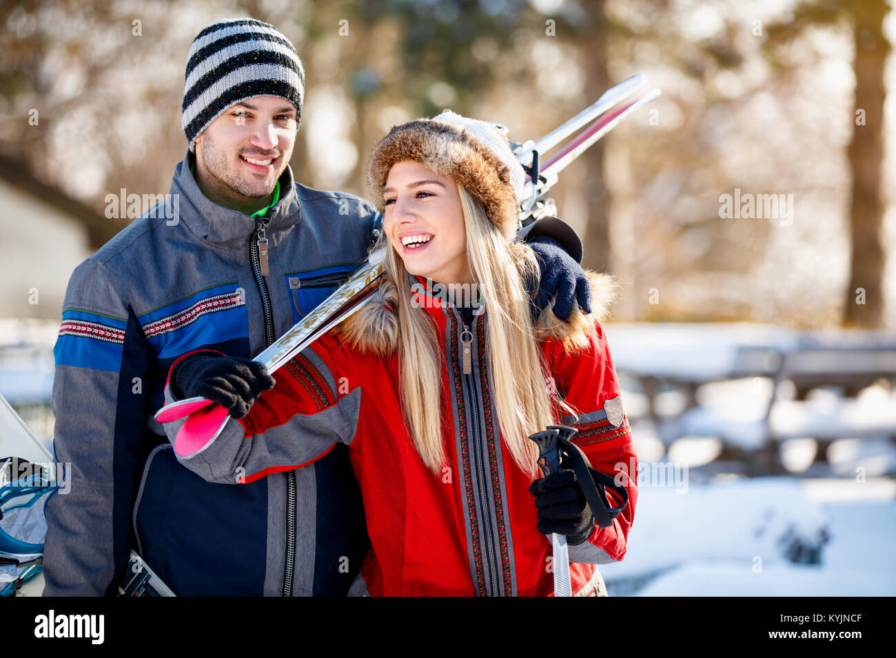 Jeune couple mettre sur des skis sur l'épaule de l'hiver Banque D'Images