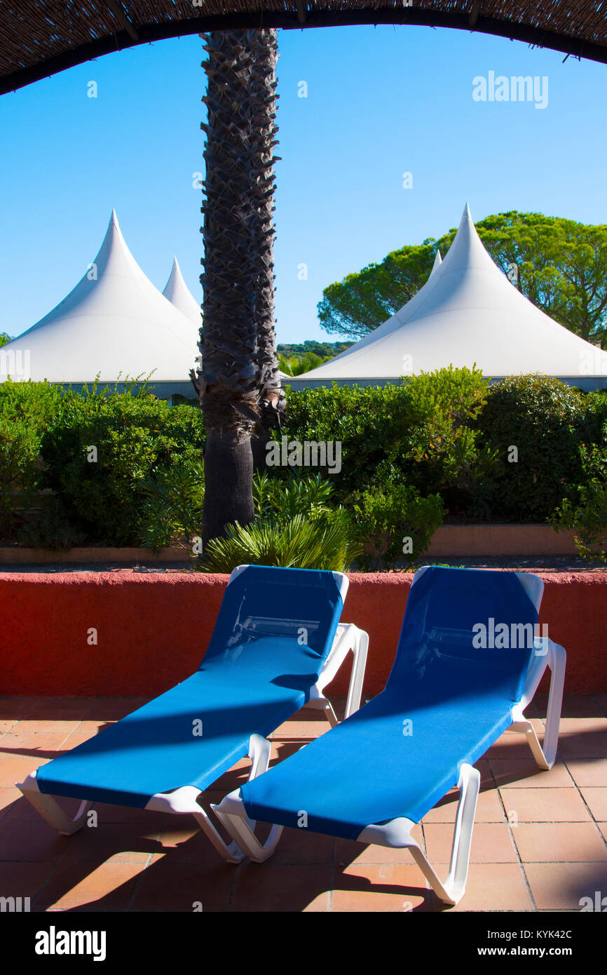 Deux chaises longues en face de tentes dans le parc de l'hôtel Dei marres à Saint Tropez, France Banque D'Images