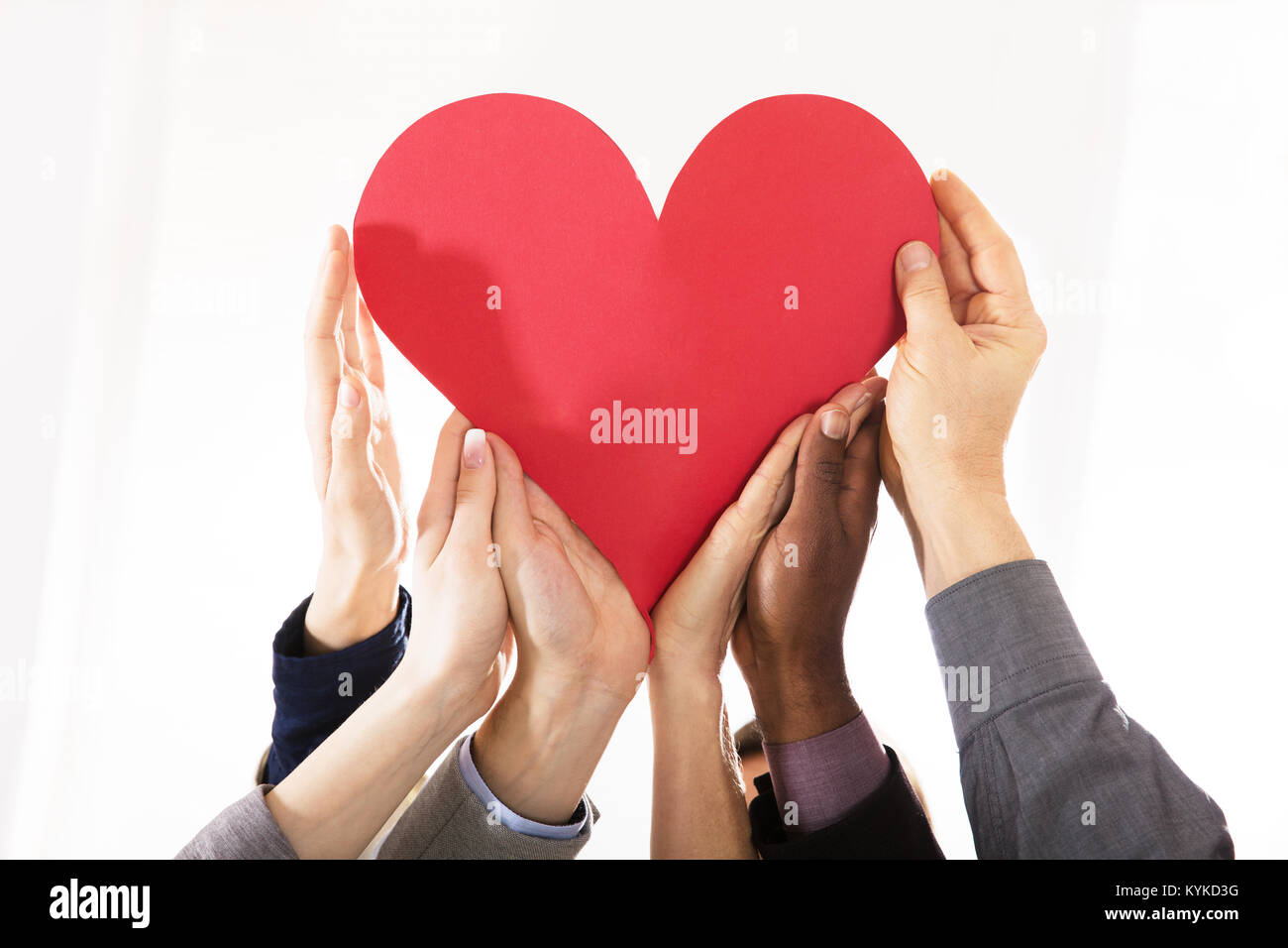Groupe d'affaires Hands Holding Papier rouge coeur contre fond blanc Banque D'Images