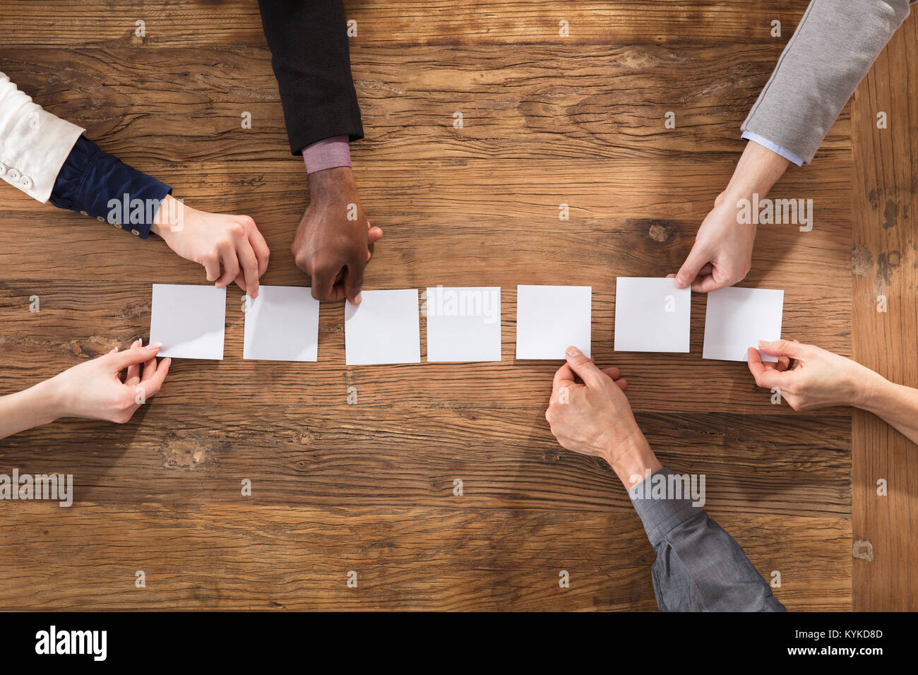Vue de dessus de Businesspeople mains Organiser Livre Blanc sur le bureau en bois Banque D'Images