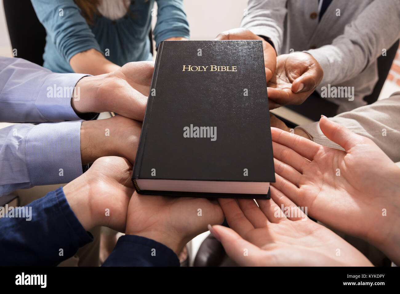 Sainte Bible sur les mains de diverses personnes Banque D'Images