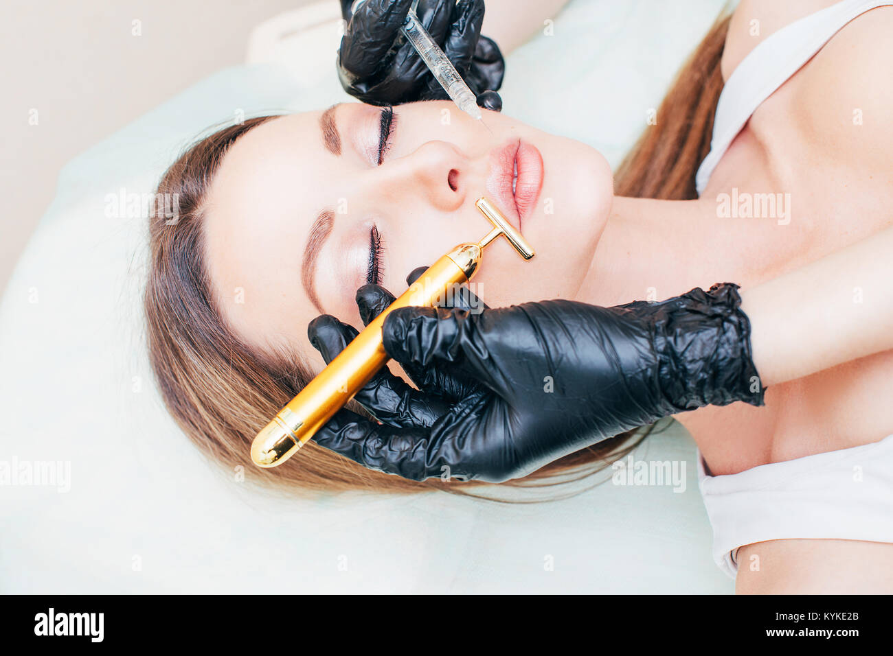 Close up de mains d'injection de botox dans cosmetologist les lèvres. Elle est holding syringe. La belle jeune femme reçoit une procédure wit Banque D'Images