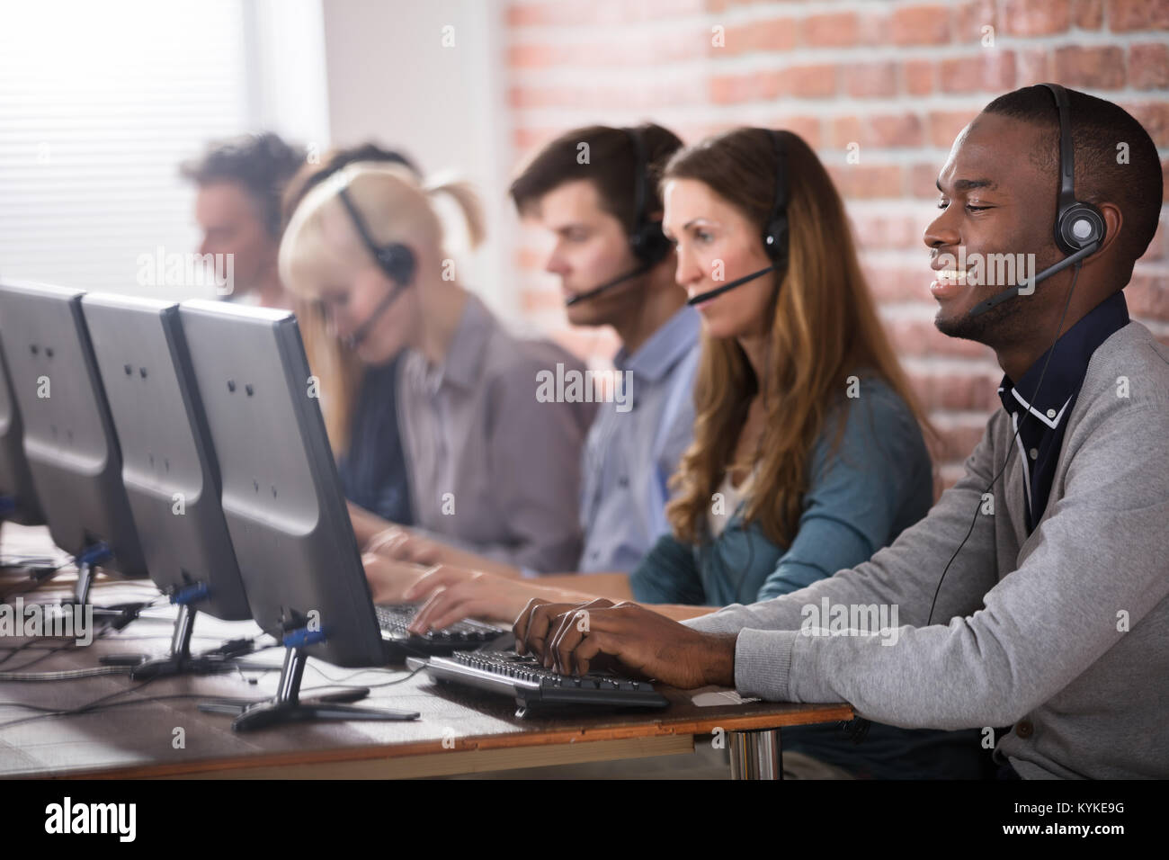 Les jeunes de l'équipe du Centre d'appel parlant avec des clients Banque D'Images