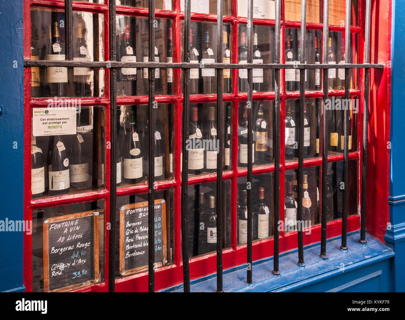 Des barres de fer de protéger les bouteilles de vin affiche dans une vitrine dans Paris France. Banque D'Images