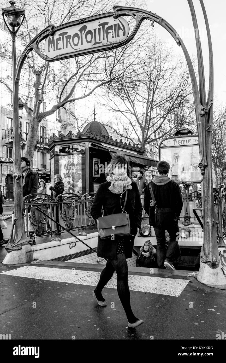 PARIS-JAN 2, 2014:Local parisiens marche autour de la célèbre Place Pigalle, avec entrée de métro art nouveau cadre distinctif du fer. Le noir et blanc Banque D'Images