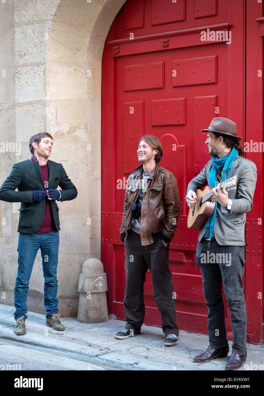 PARIS - Jan 2 2014, rue non identifié : musicien joue devant une porte rouge dans le quartier historique et animé du Marais. Banque D'Images