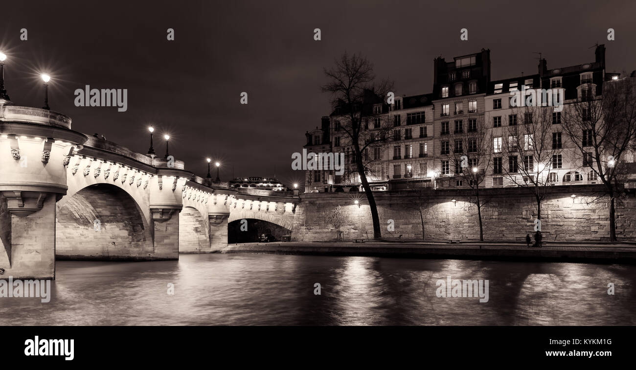 Bâtiments et ponts illuminés de Paris la nuit avec des reflets dans la Seine. Sépia noir et blanc Banque D'Images