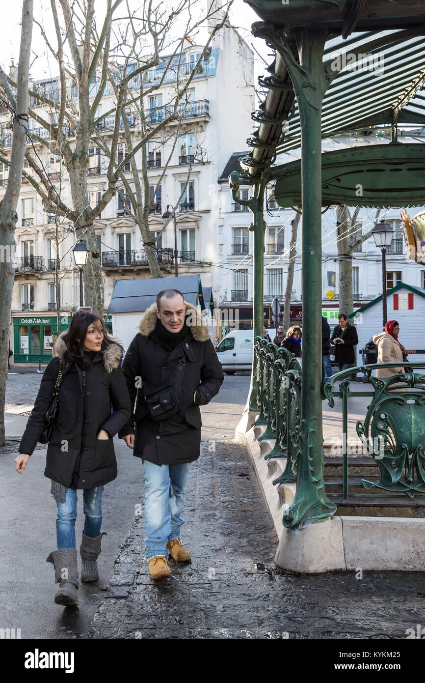Paris, France. Un couple marche par une célèbre station de métro art nouveau avec des rampes et une verrière, une des plus belles de Paris. Banque D'Images