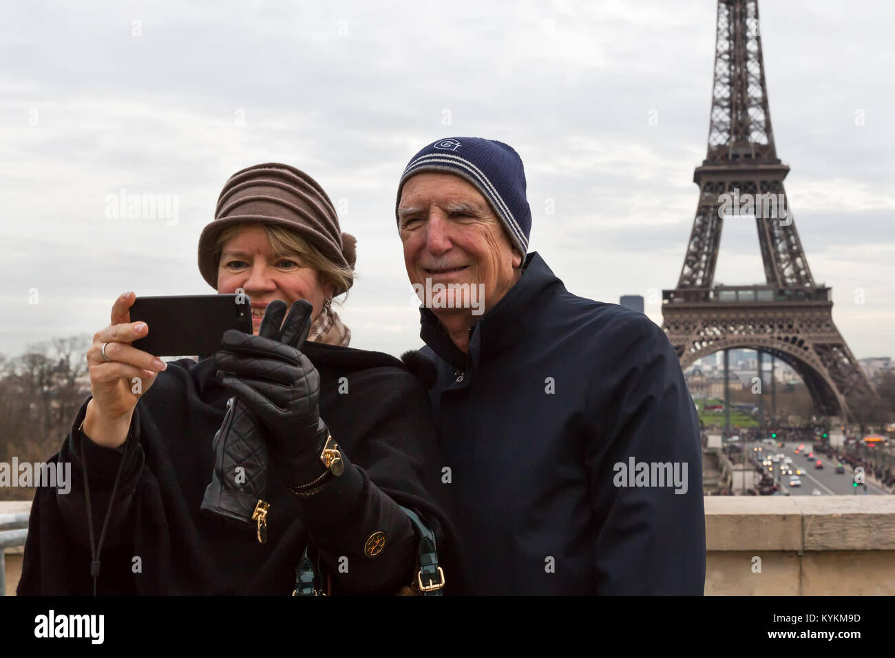 Paris France senior tourist couple prendre un cellulaire avec selfies la Tour Eiffel en arrière-plan. Ils sourient et de poser pour la photo. Banque D'Images