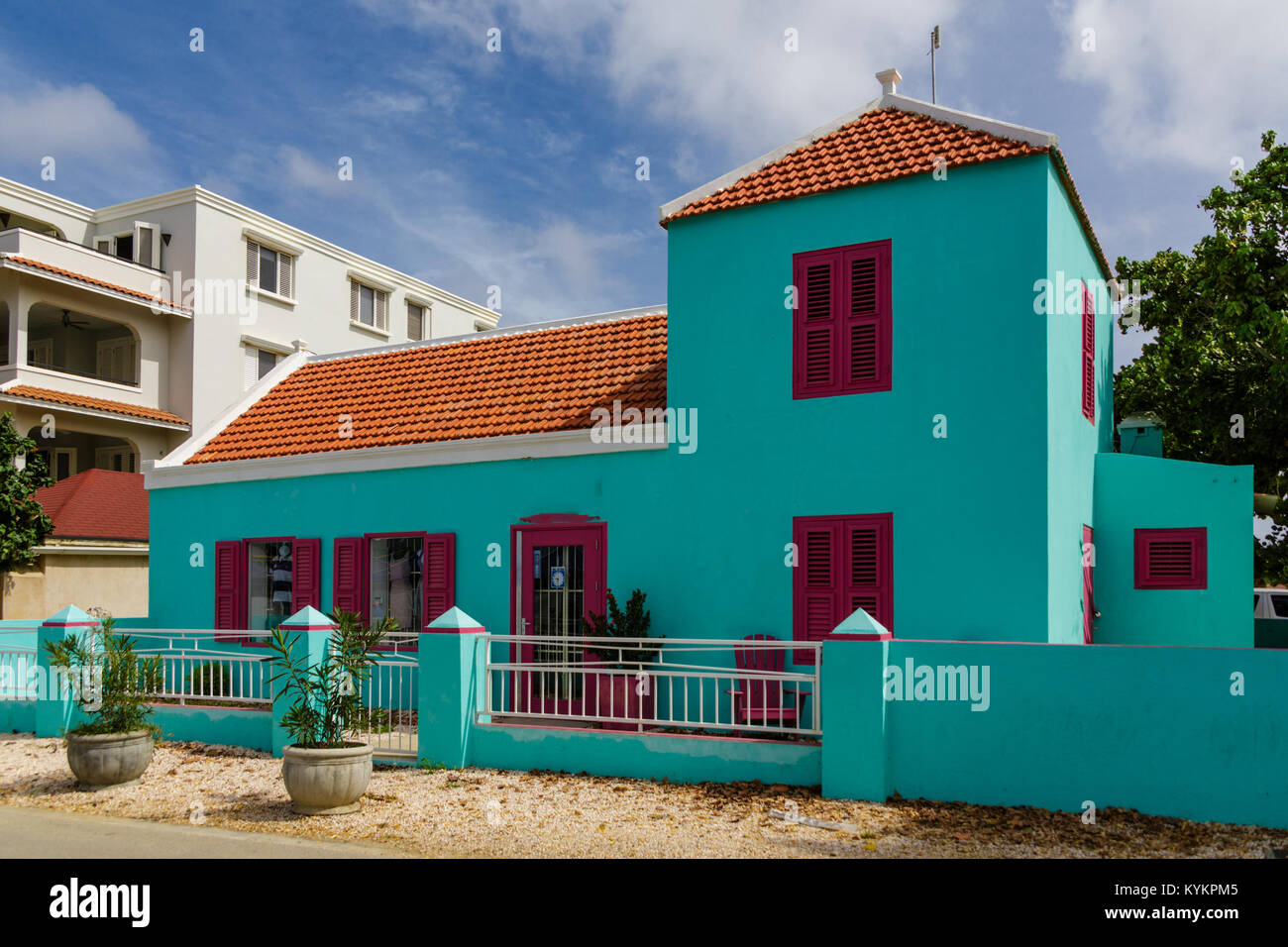 Une eau turquoise bâtiment en stuc avec toit en tuiles rouges et des volets violet Banque D'Images
