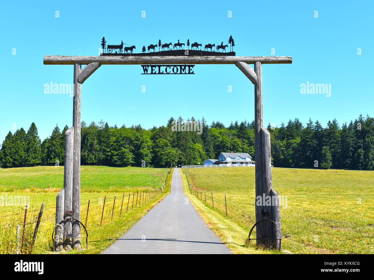 Beau ranch dans la campagne du nord-ouest du Pacifique de Ferndale, Washington, USA. L'entrée en bois a une vieille charrette tirée par les chevaux historiques un Banque D'Images
