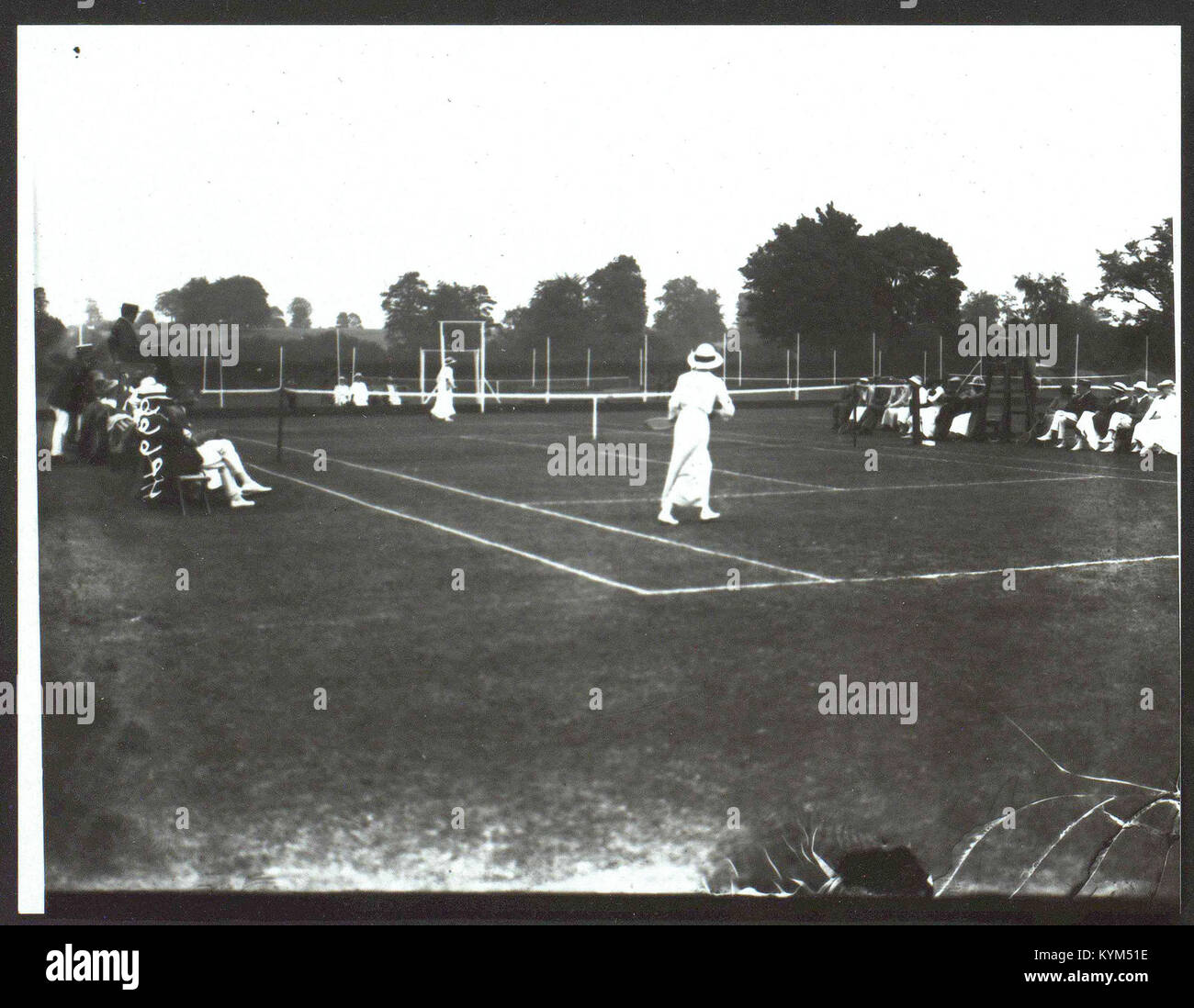 Cette photographie historique d'Armagh montre une exposition de tennis féminin, capturant l'événement sportif en Irlande du Nord. L’image donne un aperçu de la culture du tennis au début du XXe siècle et de l’implication des femmes dans le sport. Banque D'Images