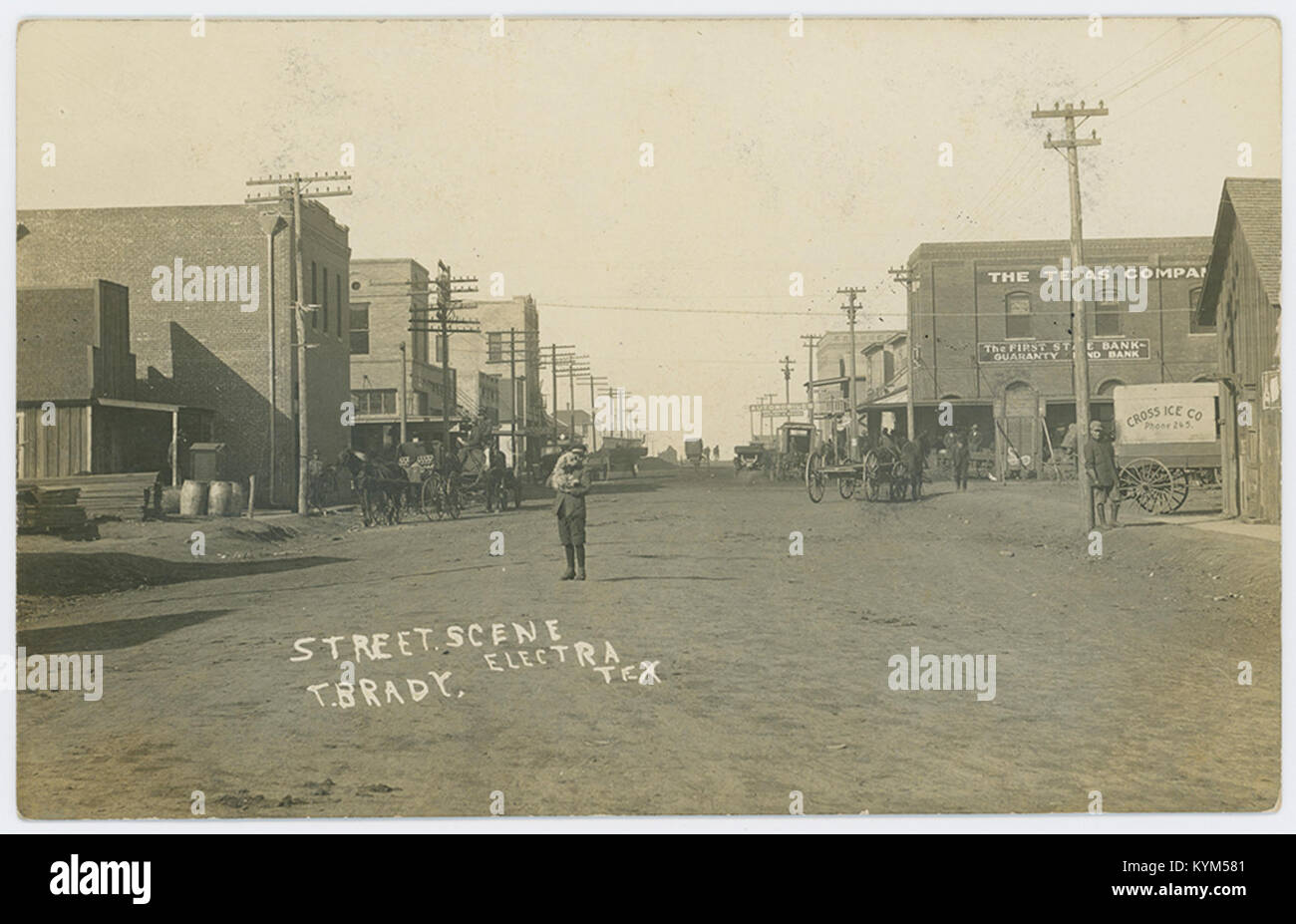 Une scène de rue historique d'Electra, Texas, montrant un instantané de la vie au début du XXe siècle avec des automobiles et des véhicules tirés par des chevaux dans la rue. La photographie capture la transition dans les transports et la vie quotidienne durant cette période. Banque D'Images