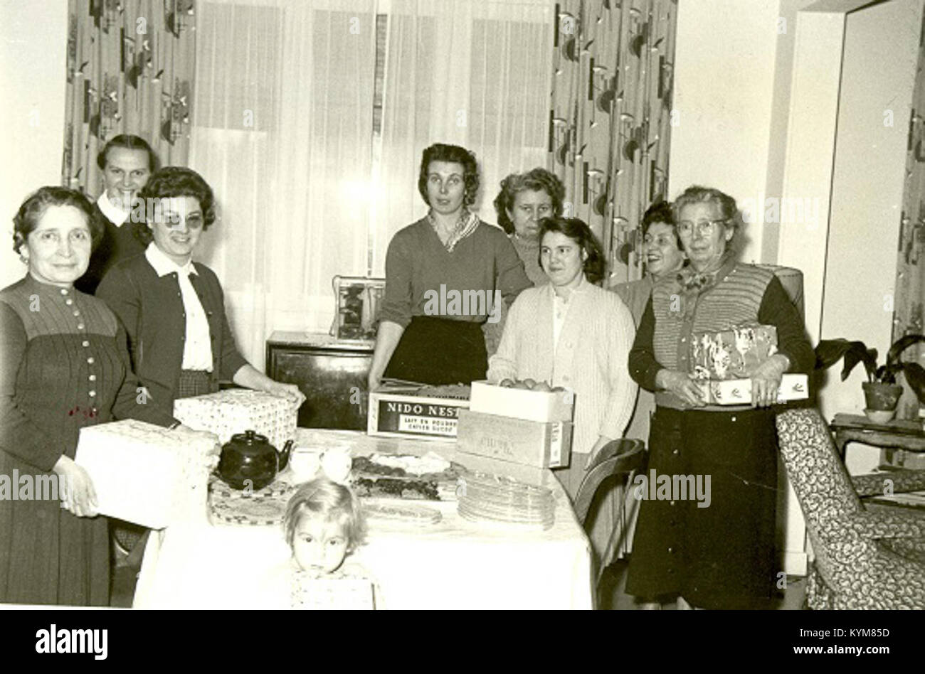 Cette image représente un groupe de femmes dans le foyer fraternel à Paris, en France, qui fait partie du Conseil des missions mennonites, capturé dans une vieille photographie historique. La scène présente les femmes rassemblées dans le foyer du bâtiment, reflétant le contexte historique culturel et religieux. Banque D'Images