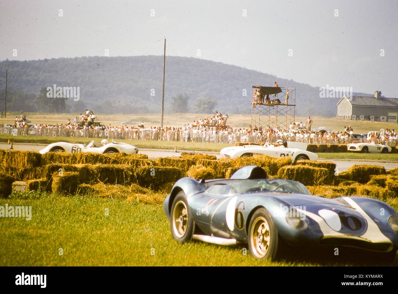 Vue de la Mk Lance Reventlow, 17 août 1958. Je Scarab race car n° 6, vu en bas à droite avec un affaiblissement de l'avant à la suite d'un accident dans la doublure des bottes de foin le cours à la SCCA races nationales de Montgomery, New York. Dans l'arrière-plan, des centaines de spectateurs regarder dans le Walt Hansgen Lister-Jaguar No 60 de l'avant course de Richard Lyeth dans son Hi-Tork n° spécial 91. Garée à droite centre edge est une Austin Healy peint blanc no 29. () Banque D'Images