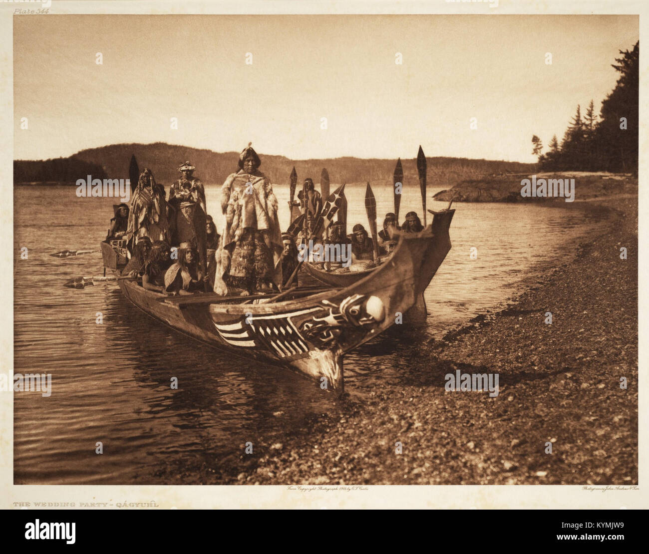 Photographie historique d'Edward Curtis représentant une fête de mariage dans un canoë décoré. L'image, originaire de la communauté amérindienne Qagyuhl, montre un événement culturel important du début des années 1900, mettant l'accent sur les traditions et les coutumes des peuples autochtones. Banque D'Images