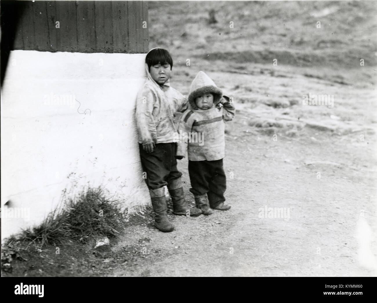 Une photo historique en noir et blanc de 1936 montrant des enfants autochtones à Ammassalik (aujourd'hui Tasiilaq), au Groenland. L’image offre un aperçu de la vie quotidienne et de la culture de la population indigène du Groenland au début du XXe siècle. Banque D'Images
