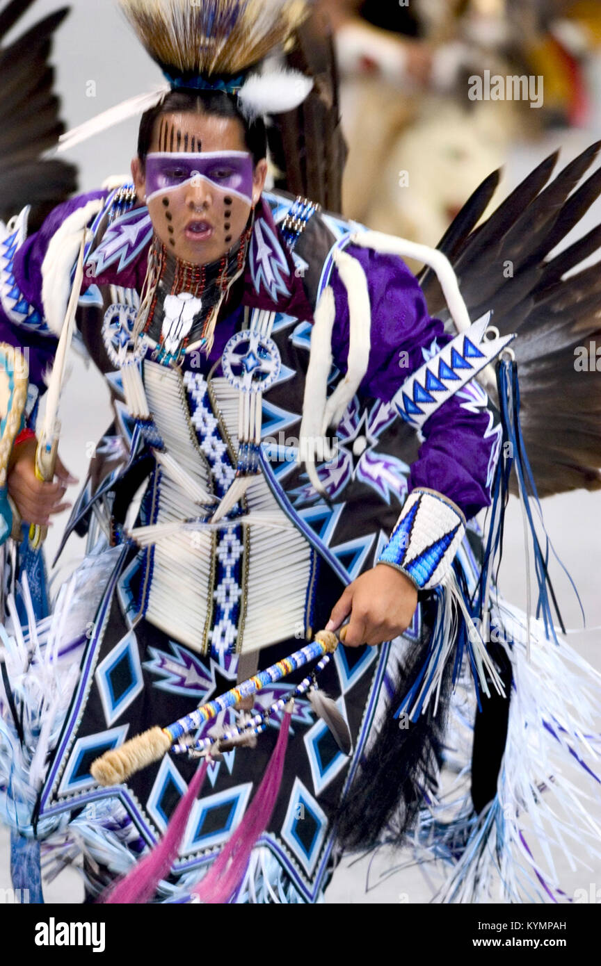 Photographie d'un homme amérindien dans des regalia traditionnelles jouant dans un pow-wow au 21ème siècle. L'image capture les couleurs vives et les traditions culturelles de la danse et des vêtements amérindiens. Banque D'Images