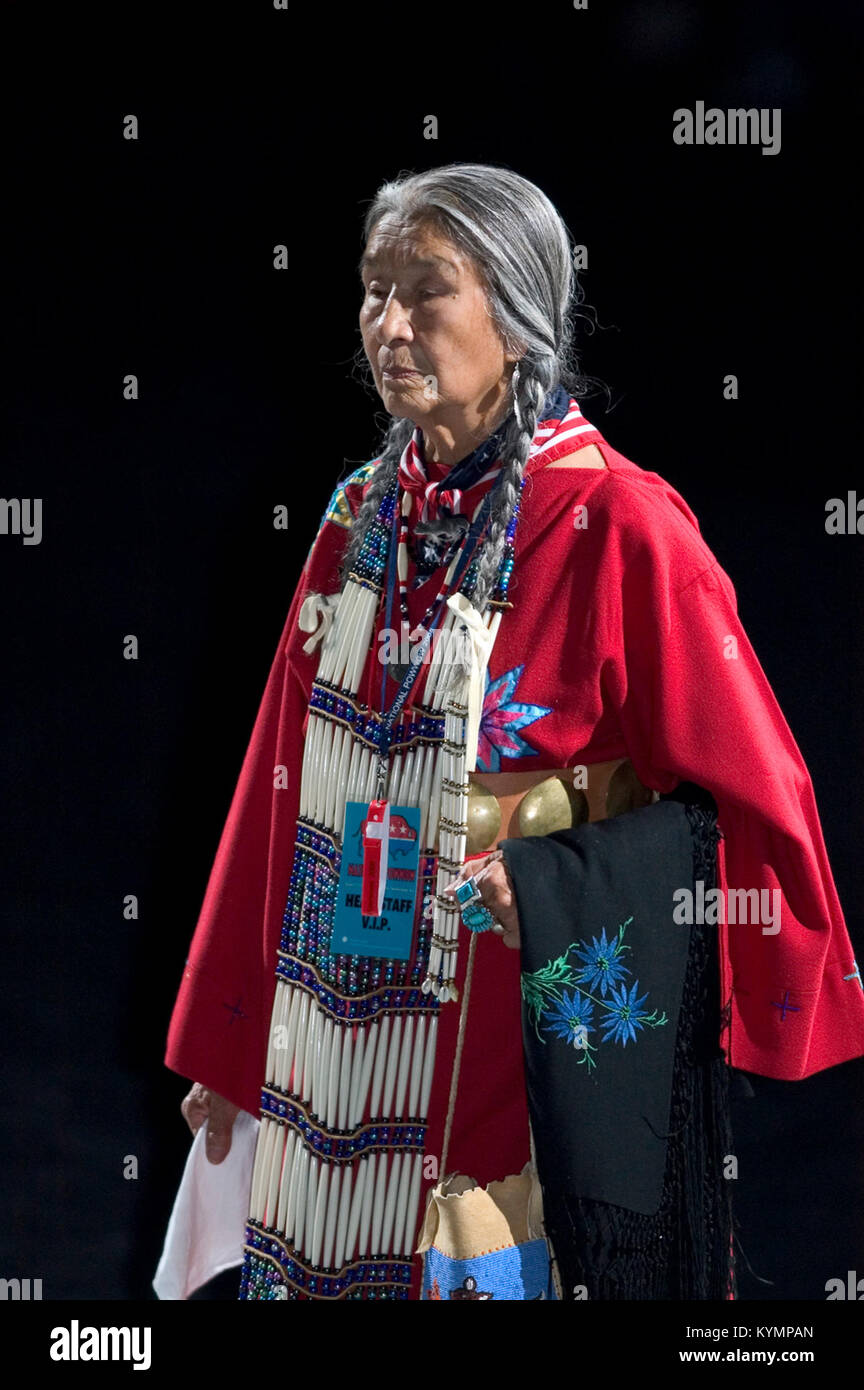Une photographie de l'événement Powwow de 2005, capturant une femme amérindienne âgée portant un châle rouge et une tenue traditionnelle. L'image reflète le patrimoine culturel des communautés amérindiennes. Banque D'Images