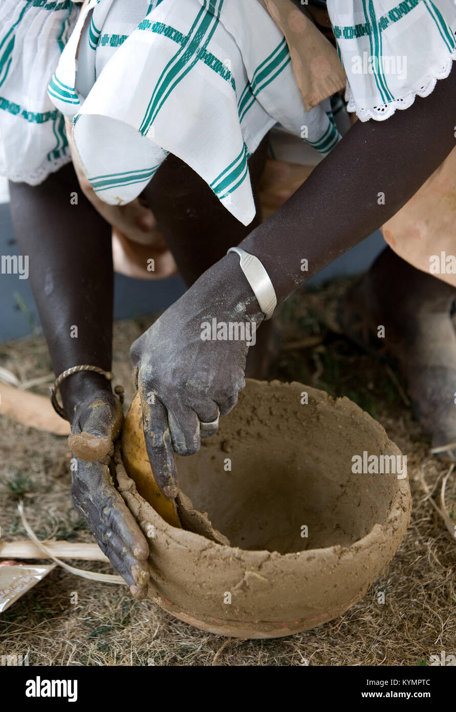 Cette image montre une potier sénégalaise, participant au Festival de la vie folklorique, capturant son talent dans la poterie en argile et mettant en valeur la culture africaine. Banque D'Images