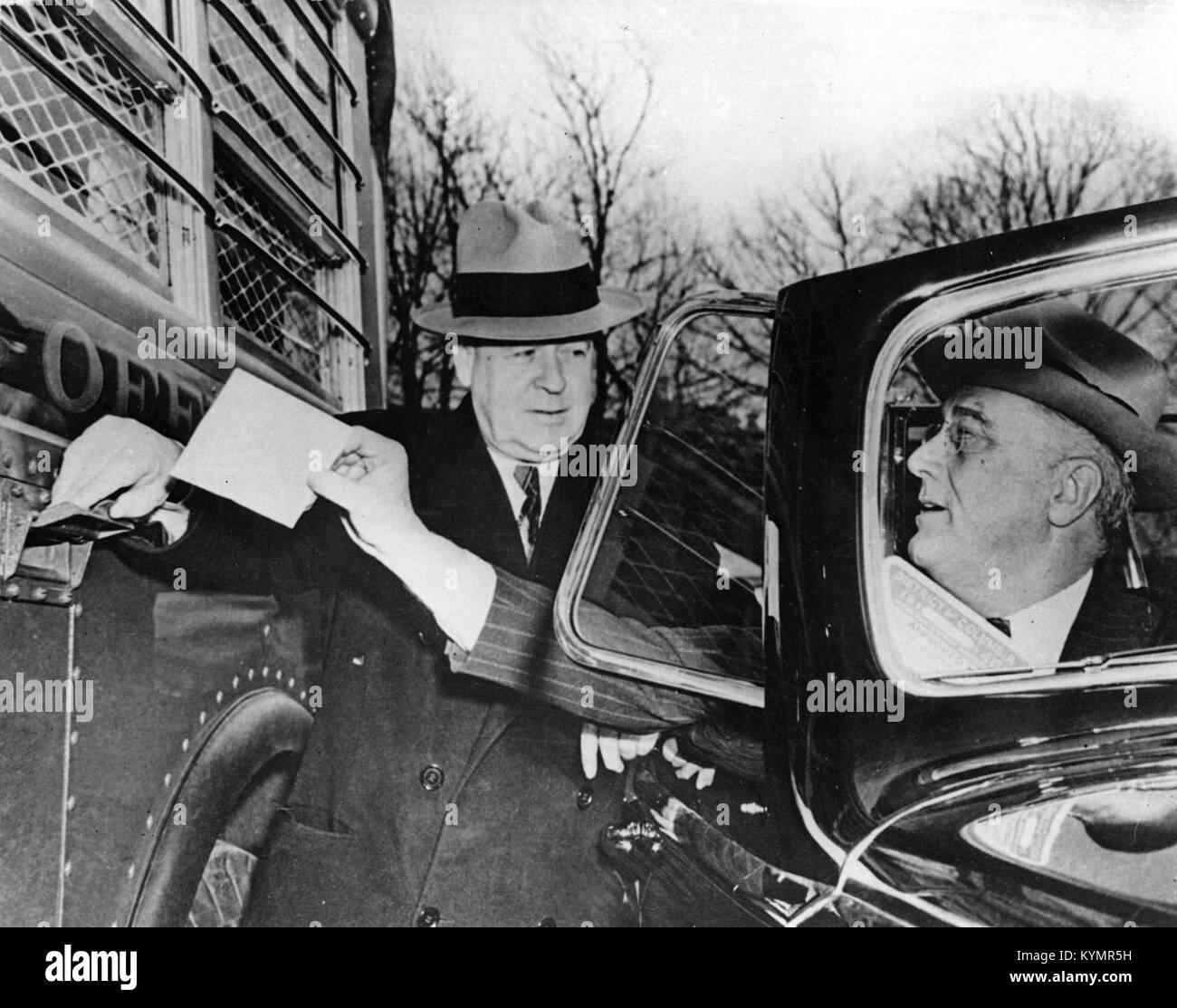 Une photographie historique montrant le président Franklin D. Roosevelt déposant une lettre dans un autobus du Highway Post Office, une image emblématique représentant le rôle des services postaux mobiles au XXe siècle. Banque D'Images
