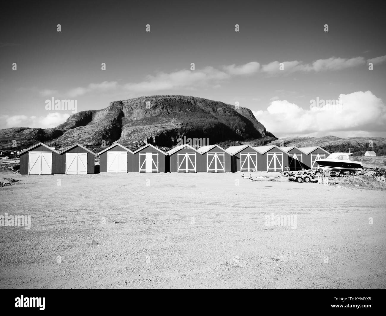 Maison de bateau rouge au quai, l'île rocky, en Norvège. Bâtiment blanc rouge traditionnelle jetée en bois à proximité de la mer froide. Rocky hill sombre en arrière-plan. Banque D'Images