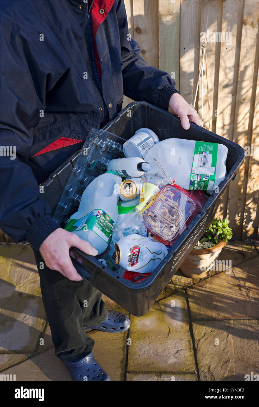 Gros plan de la personne de l'homme sortant en transportant le plastique et les boîtes de recyclage de l'étain recyclent les déchets pour la collecte Angleterre Royaume-Uni GB Grande-Bretagne Banque D'Images