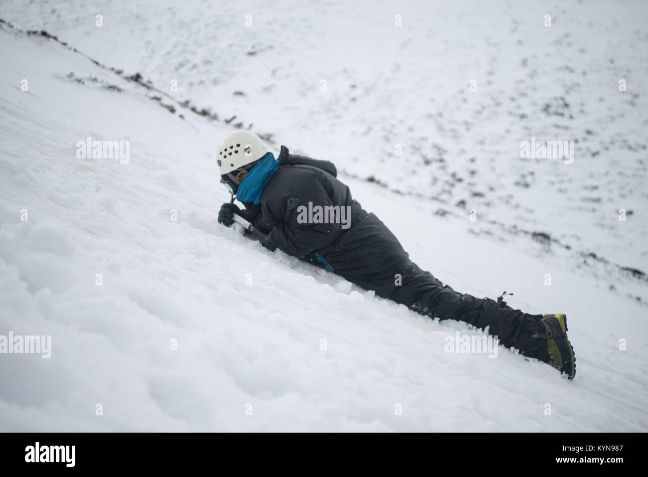 L'hiver de la formation professionnelle dans la région de montagnes de Cairngorm avant la spéléologie voyage. Marquer l'arrêt d'une diapositive avec son piolet. Banque D'Images