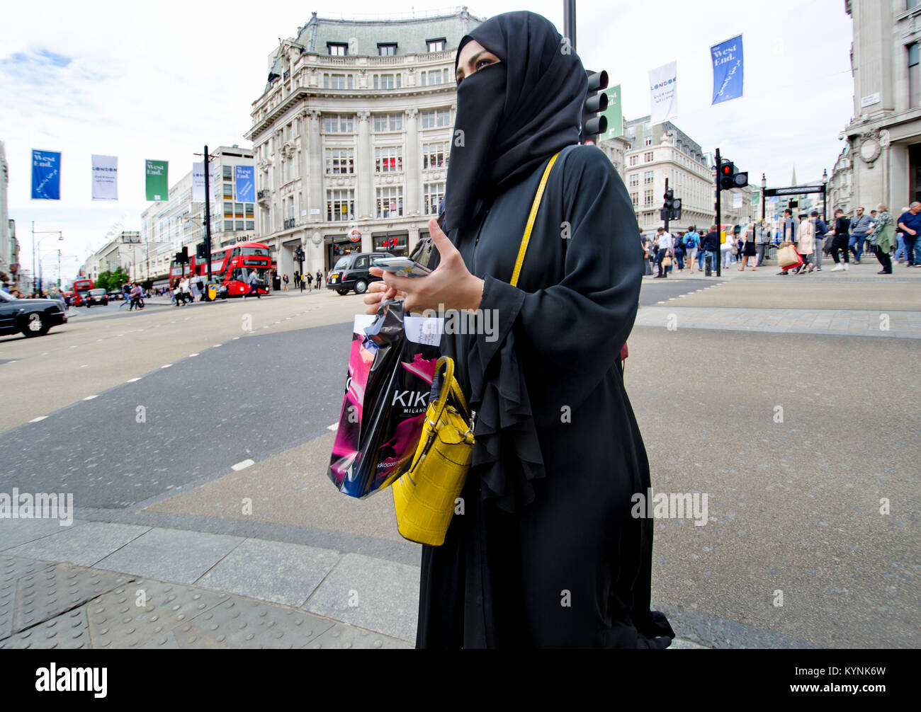 Londres, Angleterre, Royaume-Uni. Femme musulmane dans la région de Oxford Circus portant un hijab et niqaab, avec shopping Banque D'Images