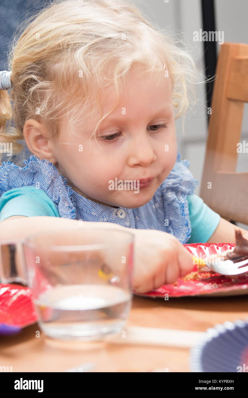 Cute little girl eating dessert sur la plaque Banque D'Images