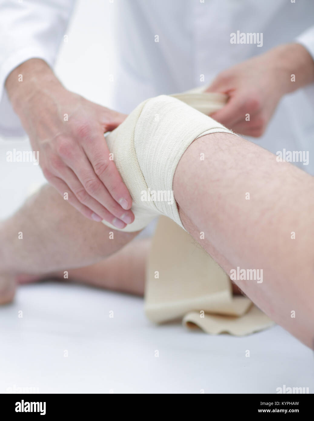 Médecin soigne plaie sur la jambe du patient dans une salle de clinique Banque D'Images