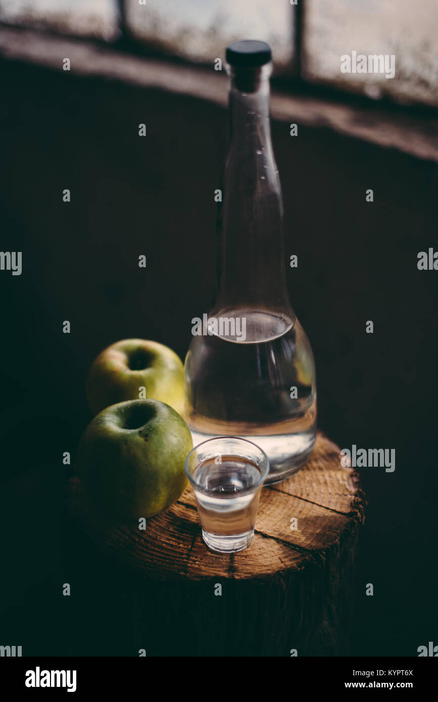 Pomme, ambiance rétro rustique. Bouteille et seul verre à boire de l'alcool de pomme verte et deux fruits. Banque D'Images