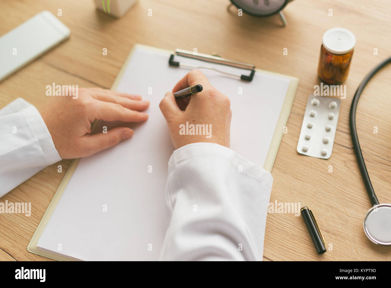 Femme médecin à écrire des notes, les antécédents médicaux du patient ou la médecine prescription sur presse-papiers papier pendant l'examen médical à l'hôpital office Banque D'Images