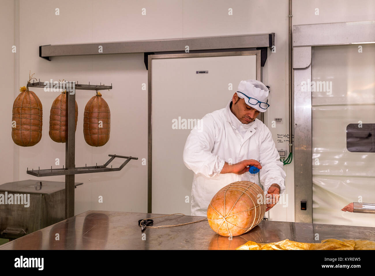 Italie Emilie Romagne Bologne Bologne Monde FICO Eataly - Consortium de mortadelle Bologna IGP - différentes phases du traitement de la mortadelle -Le forage de la mortadelle pour laisser l'air Banque D'Images