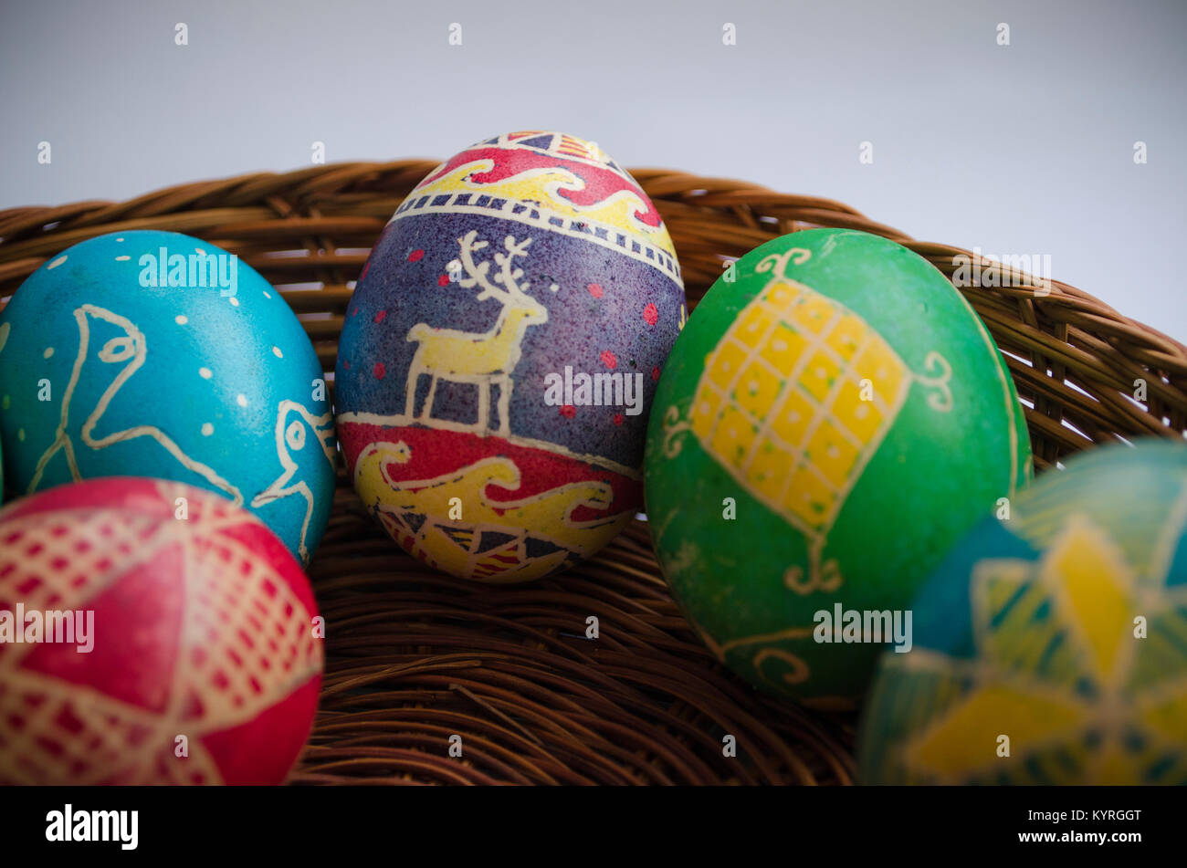 Les oeufs de Pâques peints colorés dans un panier en paille Banque D'Images