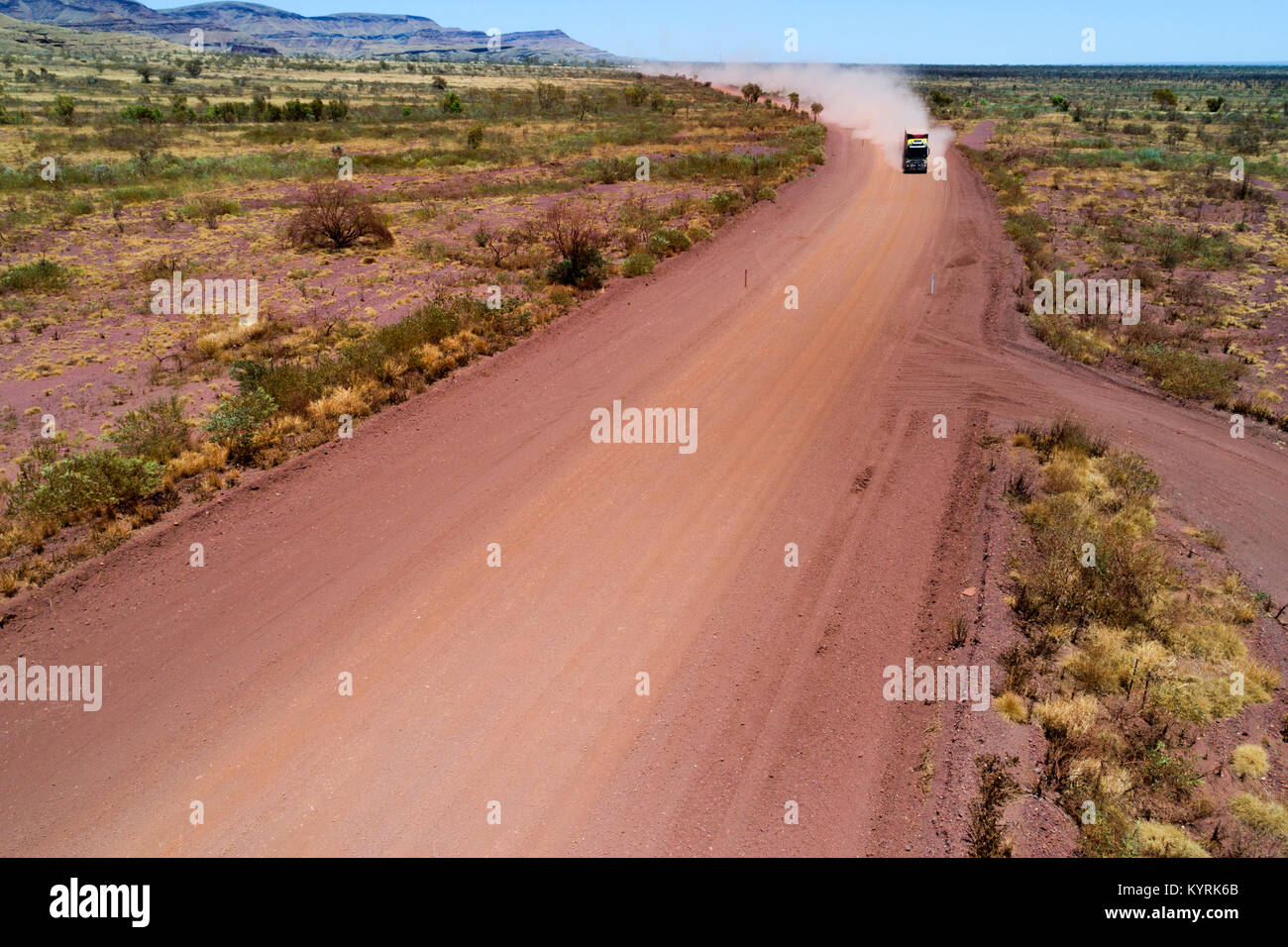 Road de chariot qui se déplace sur une route poussiéreuse rouge dans l'outback australien, Pilbara, Australie occidentale Banque D'Images