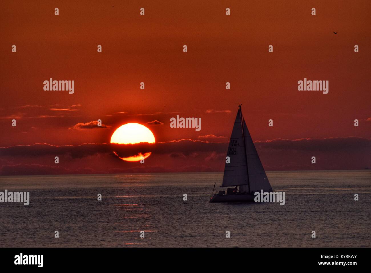 Voilier sur l'arrière-plan d'un coucher de soleil sur la mer Banque D'Images