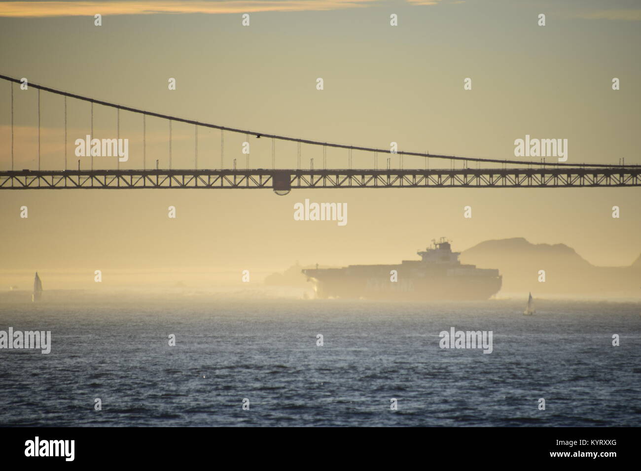 Porte-conteneurs NYK Constellation quitte San Francisco Bay sous le Golden Gate Bridge vers le coucher du soleil. Banque D'Images