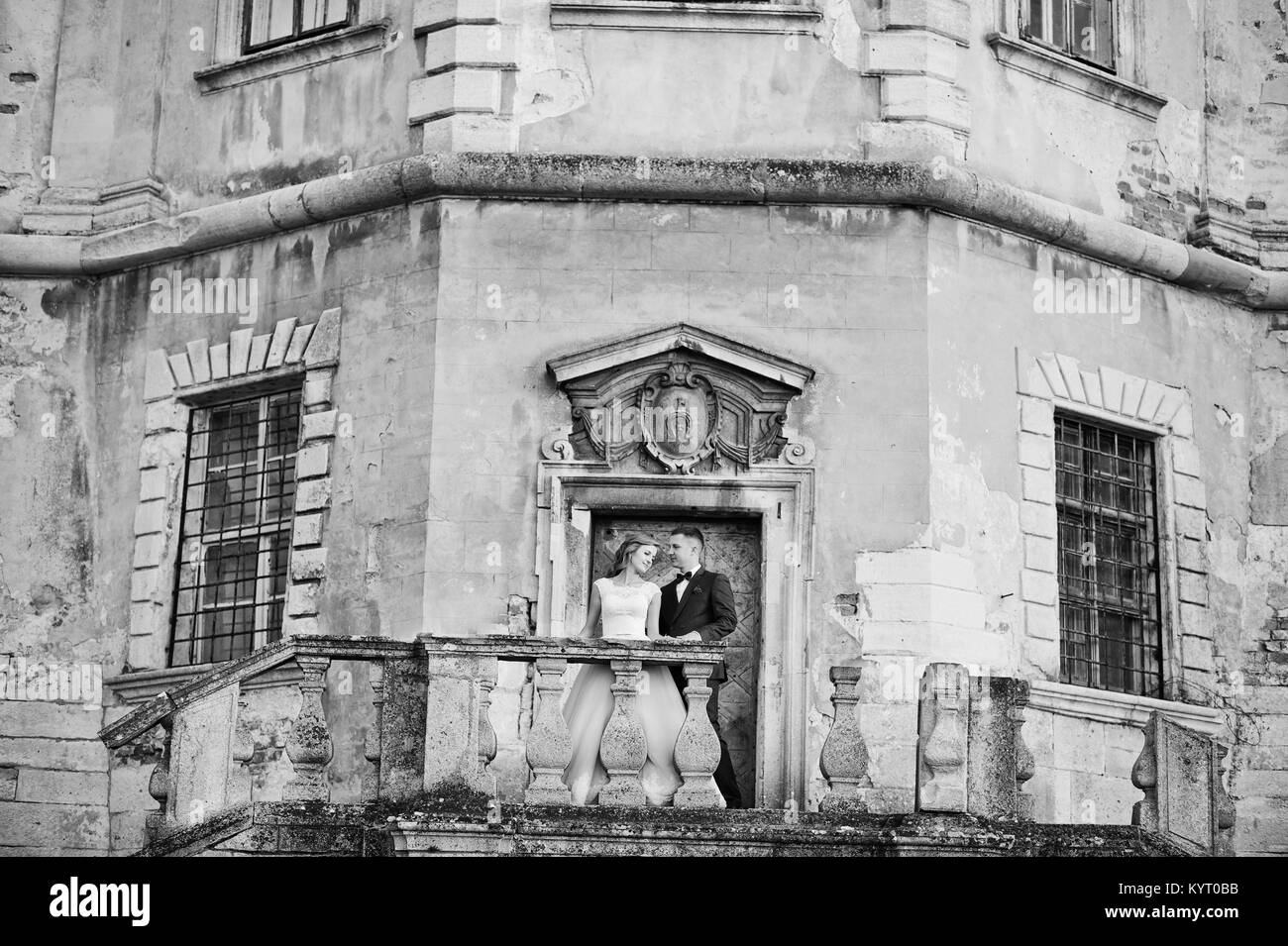 Beautiful wedding couple posing à côté du château principal portes. Photo en noir et blanc. Banque D'Images