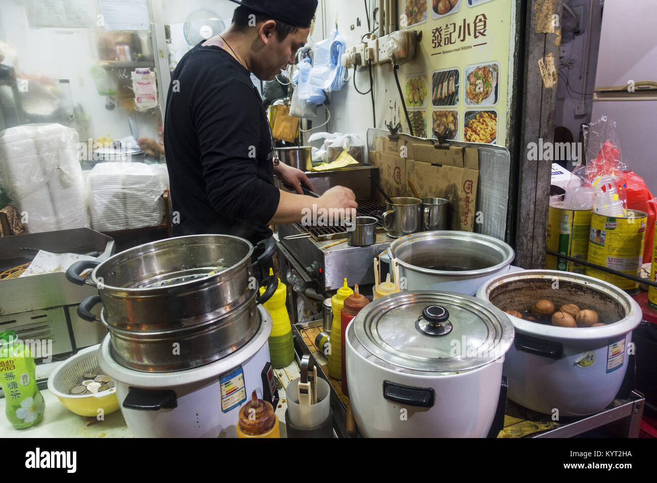 L'homme de Hong Kong la cuisson des aliments de rue Banque D'Images